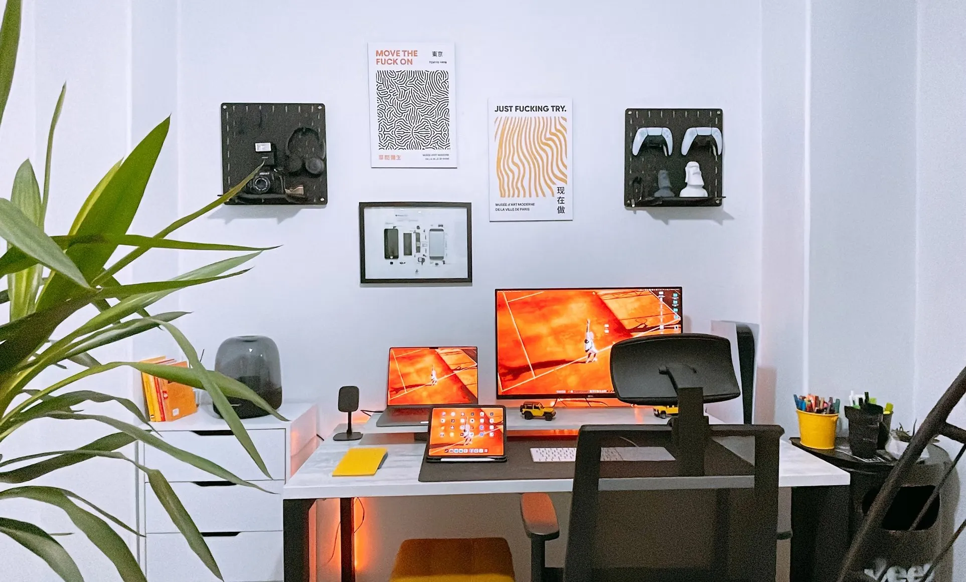 A tidy desk setup with two monitors, a laptop and plants on a white wall