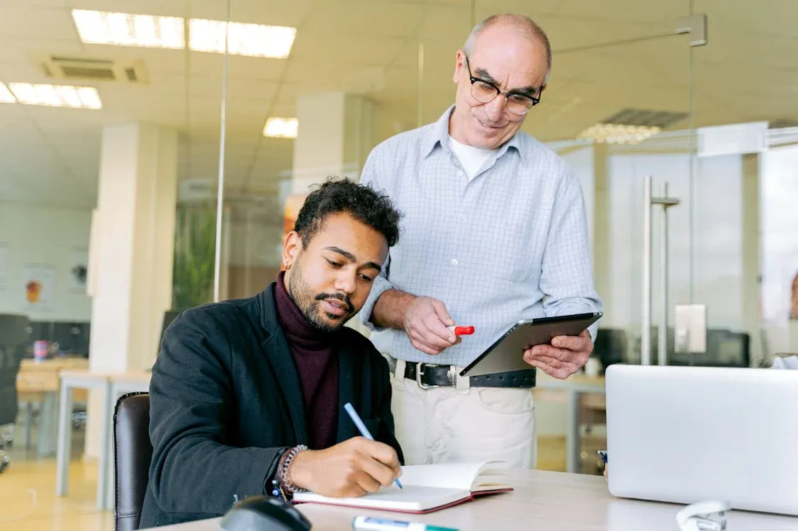 A designer and a colleague reviewing work on a tablet